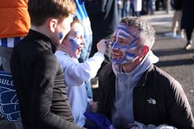 A family of Brighton & Hove Albion fans apply face paint outside the stadium prior to the Premier League match between Brighton & Hove Albion and Aston Villa