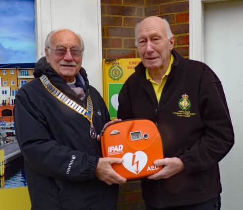 Rotary Club of Eastbourne President Graham Marsden hands over the replacement defibrillator to Eastbourne Community First Responder Fundraiser and Trustee Alec Stephens.