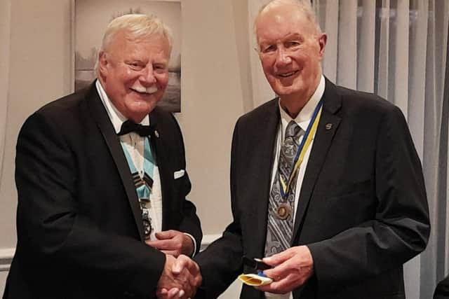 Malcolm Wykes (right) receives his award from Rotary District Governor Roger Stent
