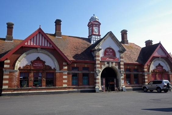 The station opened in 1902 and closed to passengers in 1964. It was built of yellow and red brick and Bath Stone dressing. Welsh slate was used on the roof which is crowned by a clocktower, and the main entrance features a block-moulded pediment. The symmetrical building comprised a large and airy booking hall, ticket and parcels offices, a waiting room and ladies toilet, as well as the stationmaster's and inspector's offices