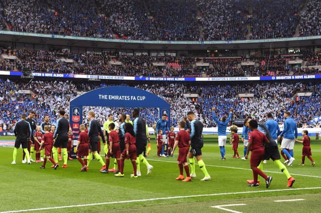 LONDON, ENGLAND - APRIL 06: The two teams walk out prior to the FA Cup Semi Final match between Manchester City  and Brighton and Hove Albion at Wembley Stadium on April 06, 2019 in London, England. (Photo by Michael Regan/Getty Images)
