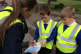 East Sussex school children helping a Civil Enforcement Officer to issue a parking ticket.