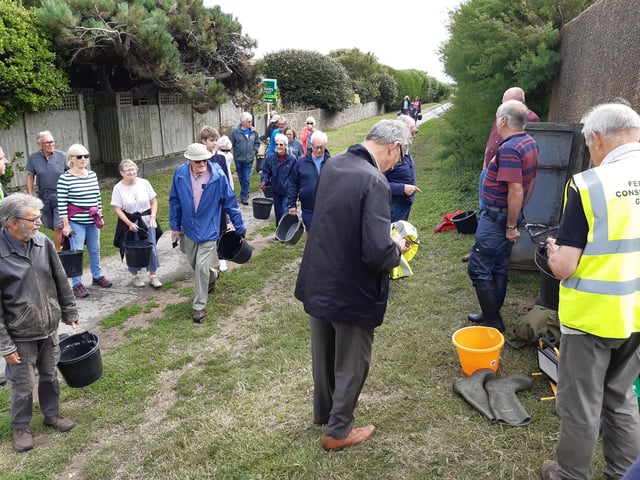 A bucket chain of volunteers from Ferring History Group and Ferring Conservation Group, including Worthing West MP Sir Peter Bottomley, form a bucket chain to bail out nine inches of water from the Ferring pillbox