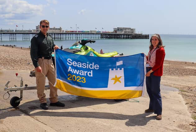 Rob Dove, Senior Coastal Warden with Cllr Vicki Wells holding the 2023 Seaside Award flag