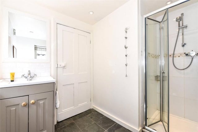 To the rear of the property, there is a lobby with access to the rear garden, ground floor shower room, and adjoining utility room with slate tiled flooring.