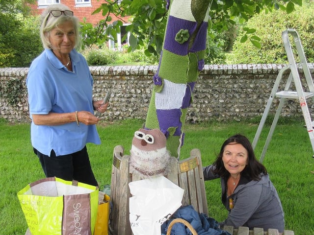 Kate Shaw and Larrie Robinson yarnbombing trees to promote a flower festival at All Saints Church in East Dean in July 2016