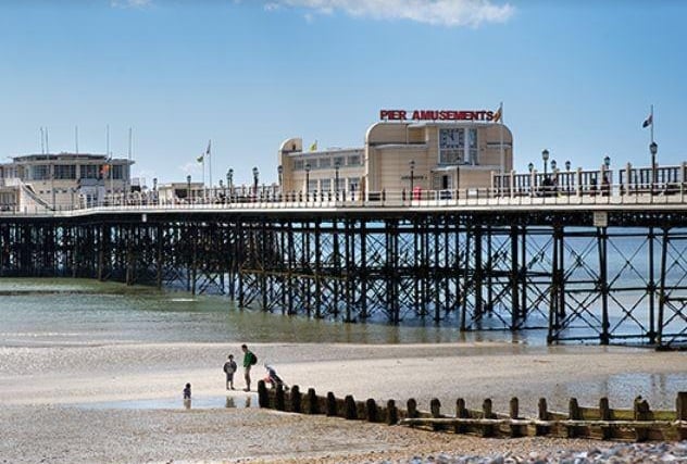 Enjoy a stroll along Worthing Pier and keep an eye out for dolphins gracefully swimming near the shoreline, offering a delightful surprise for visitors of all ages