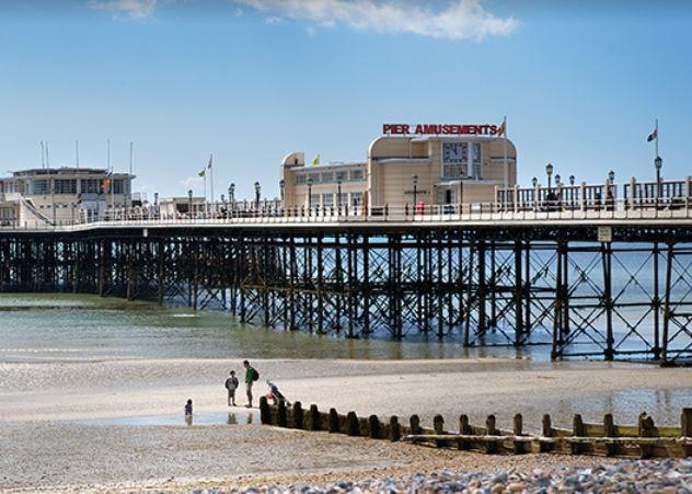 Enjoy a stroll along Worthing Pier and keep an eye out for dolphins gracefully swimming near the shoreline, offering a delightful surprise for visitors of all ages