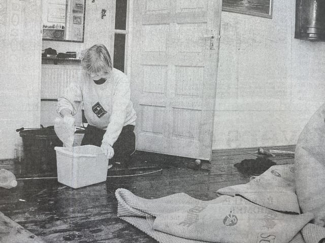 Janetta Field tries to mop up water from her floorboards in her Bosham home.