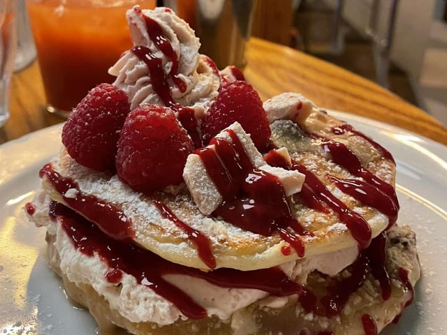The Phantom Raspberry Blower Of Old London Town is inspired by Tony’s Strawberry Cheesecake & Raspberry White Chocolate bar. Fresh raspberry pancakes, with a berry ripple cheesecake mix, topped with raspberry cream & coulis, melted Tony’s white chocolate and finished with fresh strawberries & raspberries.