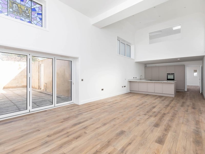 The living space is on the ground floor and boasts original high level stain glass windows