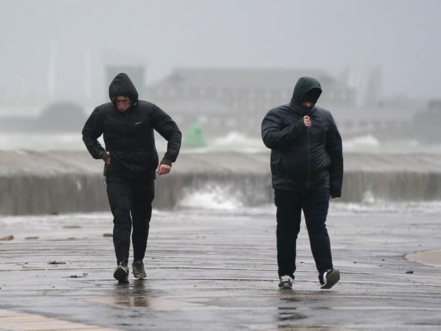 People brave the weather as they make their way along the seafront in Southsea as Storm Barra hit. Picture: Andrew Matthews/PA Wire