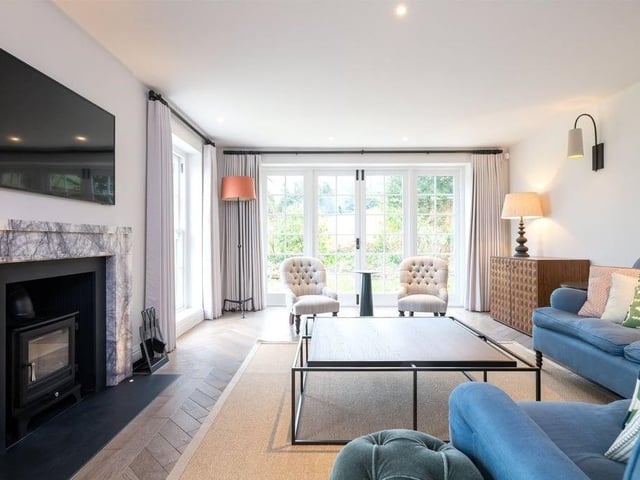 The double-aspect drawing room has a marble fireplace and a Chesney wood burner