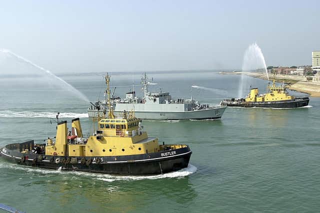 Minehunter HMS Shoreham gets a watery welcome from tugs Powerful and Bustler as she leads HMS Grimsby, HMS Ramsey, and HMS Ledbury into Portsmouth Harbour in July 2005