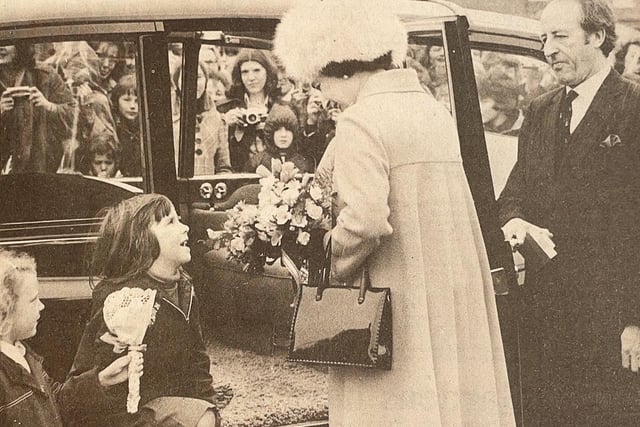 The Queen was greeted by two children who ran out of the crowd to meet her when she arrived at Chichester Station.