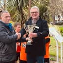 Angmering South Downs Rotary Club president Graham Scott presents the trophy to coach Paul Woodley