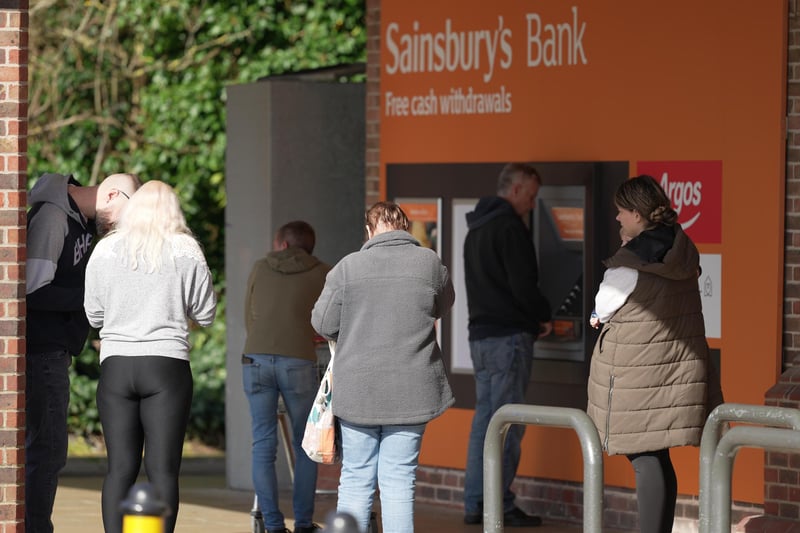People were pictured queueing for cash points outside Sainsbury’s stores in Sussex after a major IT fault, which prevented card payments.