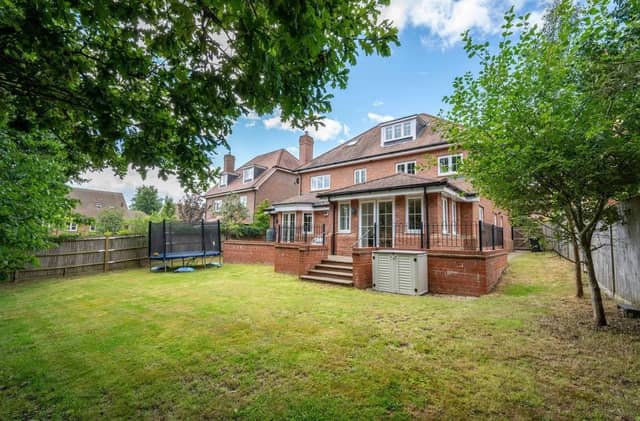 The private garden at the rear has a raised terrace area and a large lawn