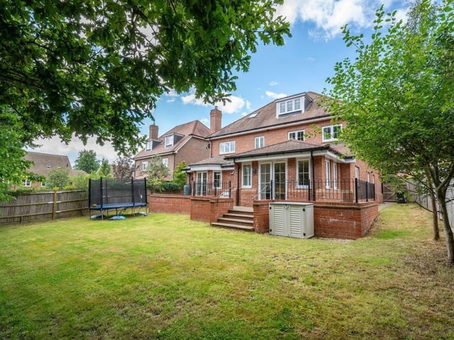 The private garden at the rear has a raised terrace area and a large lawn