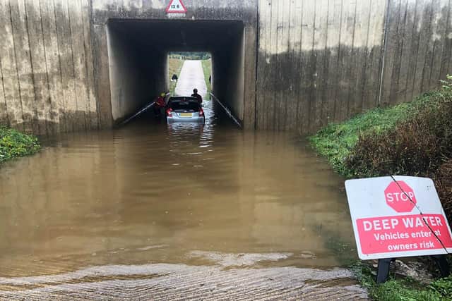 An elderly couple were rescued by fire crews when their car became stuck in floodwater between Horsham and Crawley