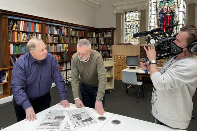 Dave Monk, left, examining old copies of the Midhurst and Petworth Observer as part of the filming.