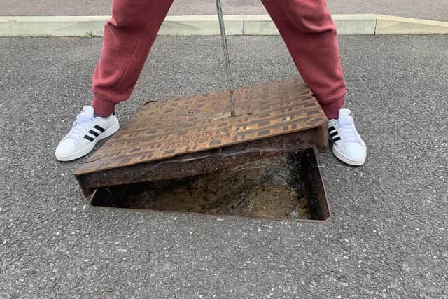 Michael show the manhole outside his home - packed with sewage