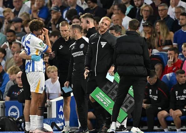Matt O'Riley of Brighton & Hove Albion (L) reacts after being substituted due to injury during the Carabao Cup Second Round match against Crawley Town
