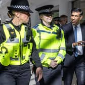 Prime Minister Rishi Sunak speaks with police officers as they walk in the corridors of the Swan Walk shopping centre during a visit in Horsham, West Sussex, on April 10, 2024 focused on retail crime. (Photo by RICHARD POHLE/POOL/AFP via Getty Images)