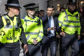 Prime Minister Rishi Sunak speaks with police officers as they walk in the corridors of the Swan Walk shopping centre during a visit in Horsham, West Sussex, on April 10, 2024 focused on retail crime. (Photo by RICHARD POHLE/POOL/AFP via Getty Images)
