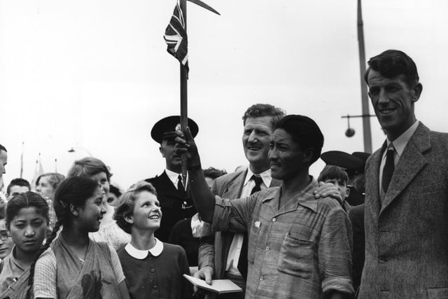 Sherpa Tensing and Edmund Hillary surrounded by admirers at Heathrow airport after their conquest of Everest.    (Photo by Topical Press Agency/Getty Images)