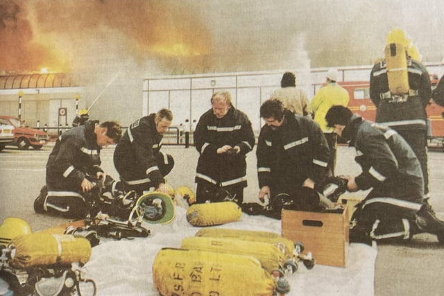 Firefighters checking their breathing apparatus.