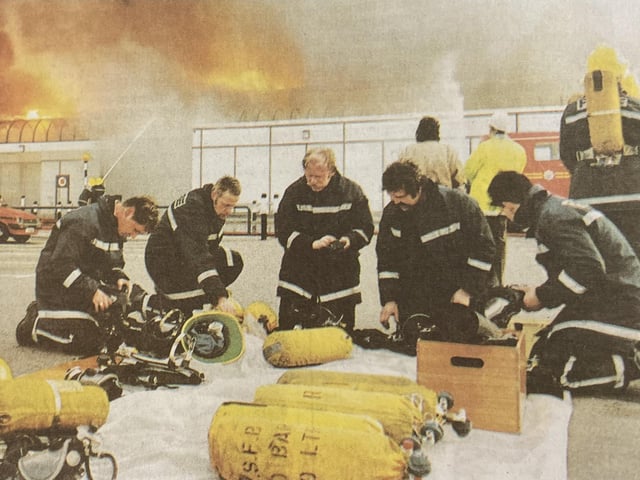 Firefighters checking their breathing apparatus.