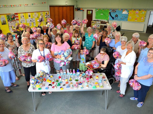 Arcade Knitters presenting more than 3,300 innocent smoothie hats to Age UK West Sussex