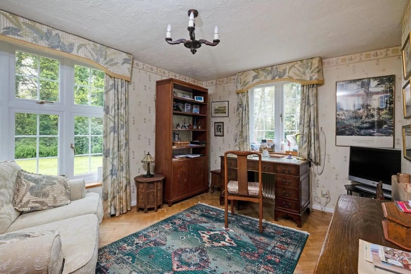A double aspect sitting room is currently used as a study