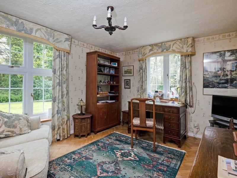 A double aspect sitting room is currently used as a study