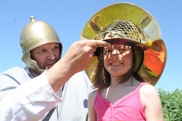 Paul Ullson helps a young visitor try on a helmet