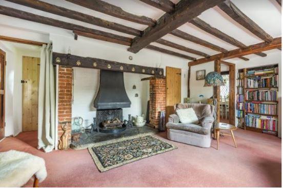The sitting room has an inglenook fireplace with a log burner