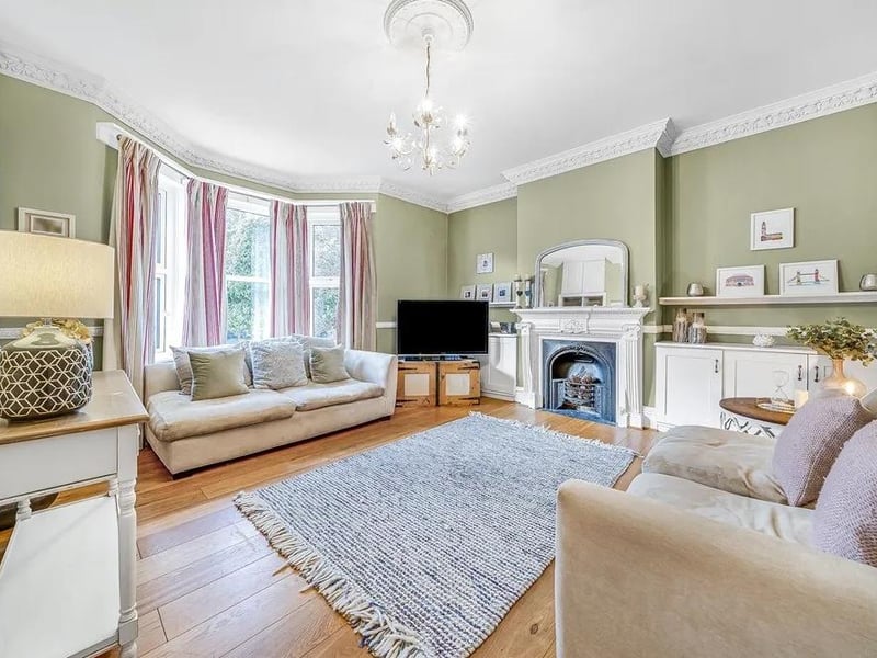 The reception room at the front of the house has oak-wood flooring, a bay window, a feature fireplace and original coving