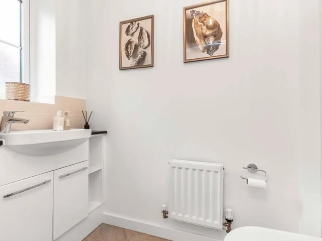 The contemporary downstairs WC includes a vanity sink unit and integrated toilet cistern