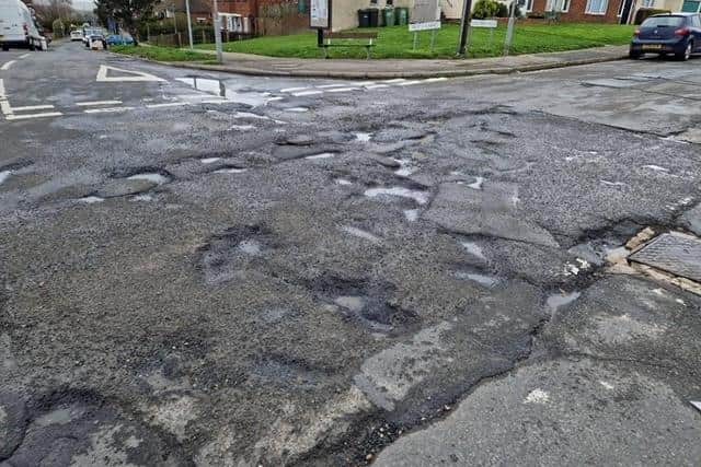 Pot hole scarred road at the junction of Winchelsea Road and Rock Lane in Hastings.