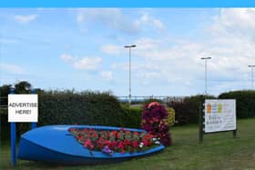 colourful flower display in boat with promotional sign