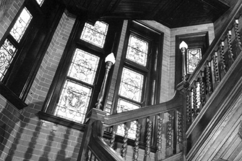 The main staircase at Rustington Convalescent Home in 1974. It is solid teak and the stained glass windows are inscribed with the home's motto, Peace and Rest.