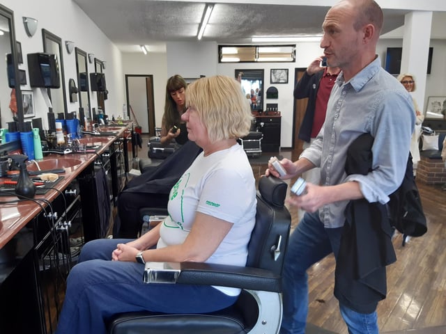 Barber Peter Jones prepares Marianne Wright for the haircut