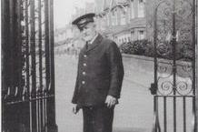 Mr Miles standing at the gardens' gate in his uniform, which he wore every day.