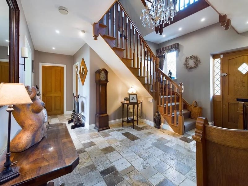 The entrance hall features a balustrade staircase that leads to a galleried landing