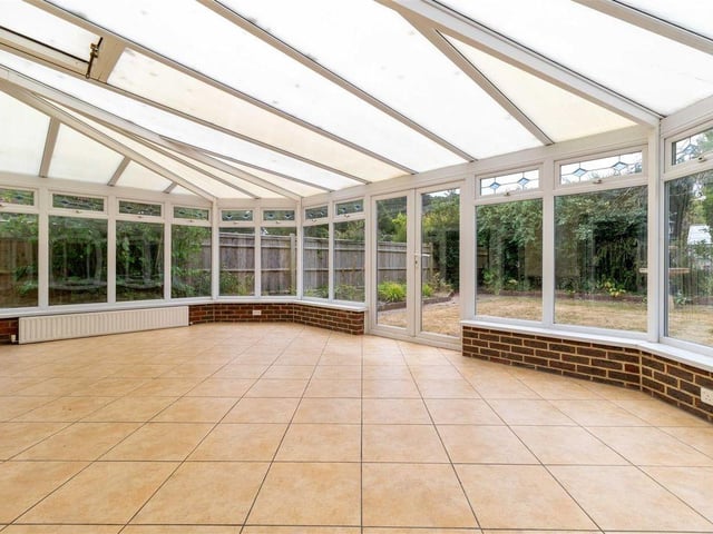 The conservatory is surrounded by double-glazed windows giving views of the garden
