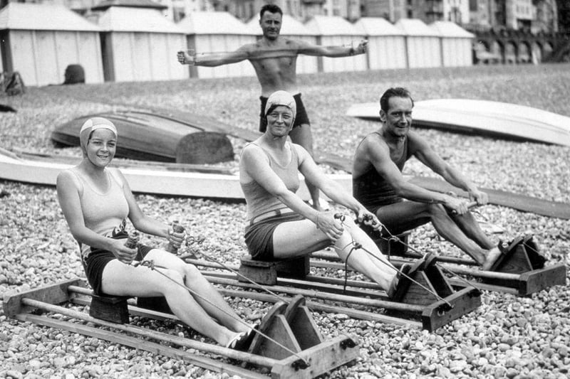 2nd August 1933:  Holiday makers exercising on Brighton beach.
