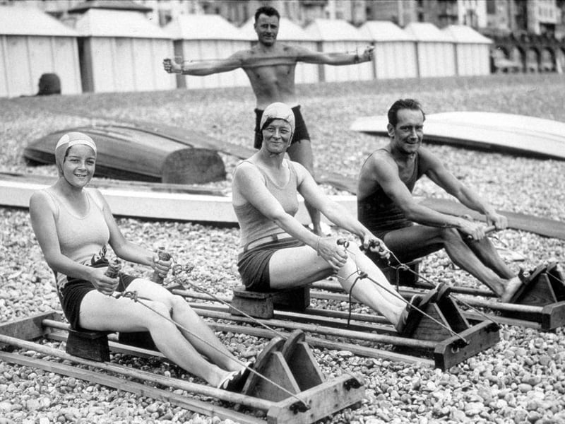 2nd August 1933: Holiday makers exercising on Brighton beach.