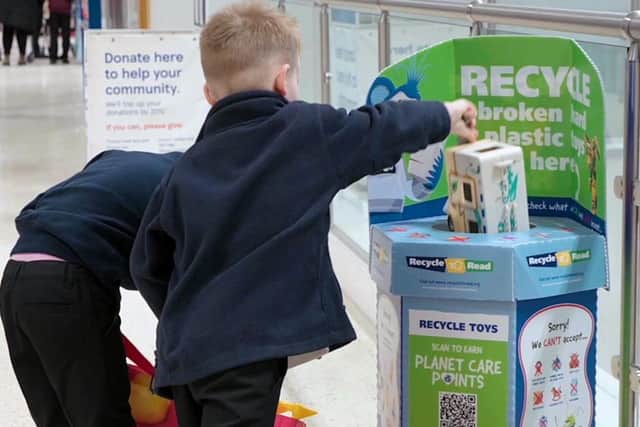 Children recycling broken toys to earn books for their school
