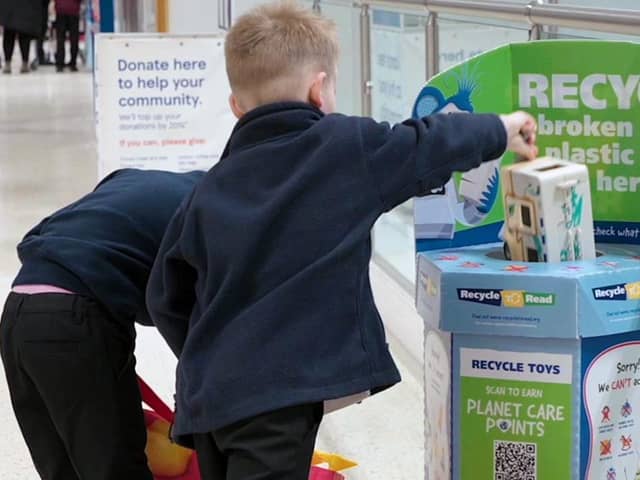 Children recycling broken toys to earn books for their school